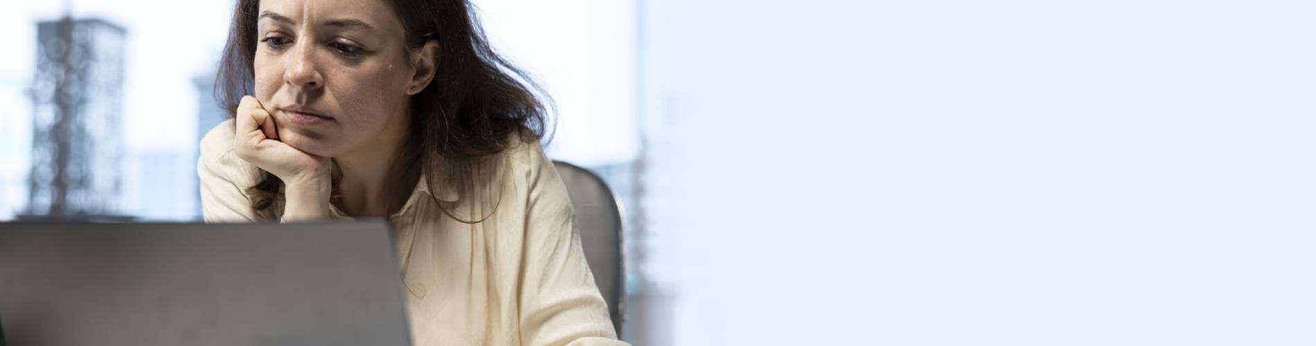 Woman focused on laptop screen.