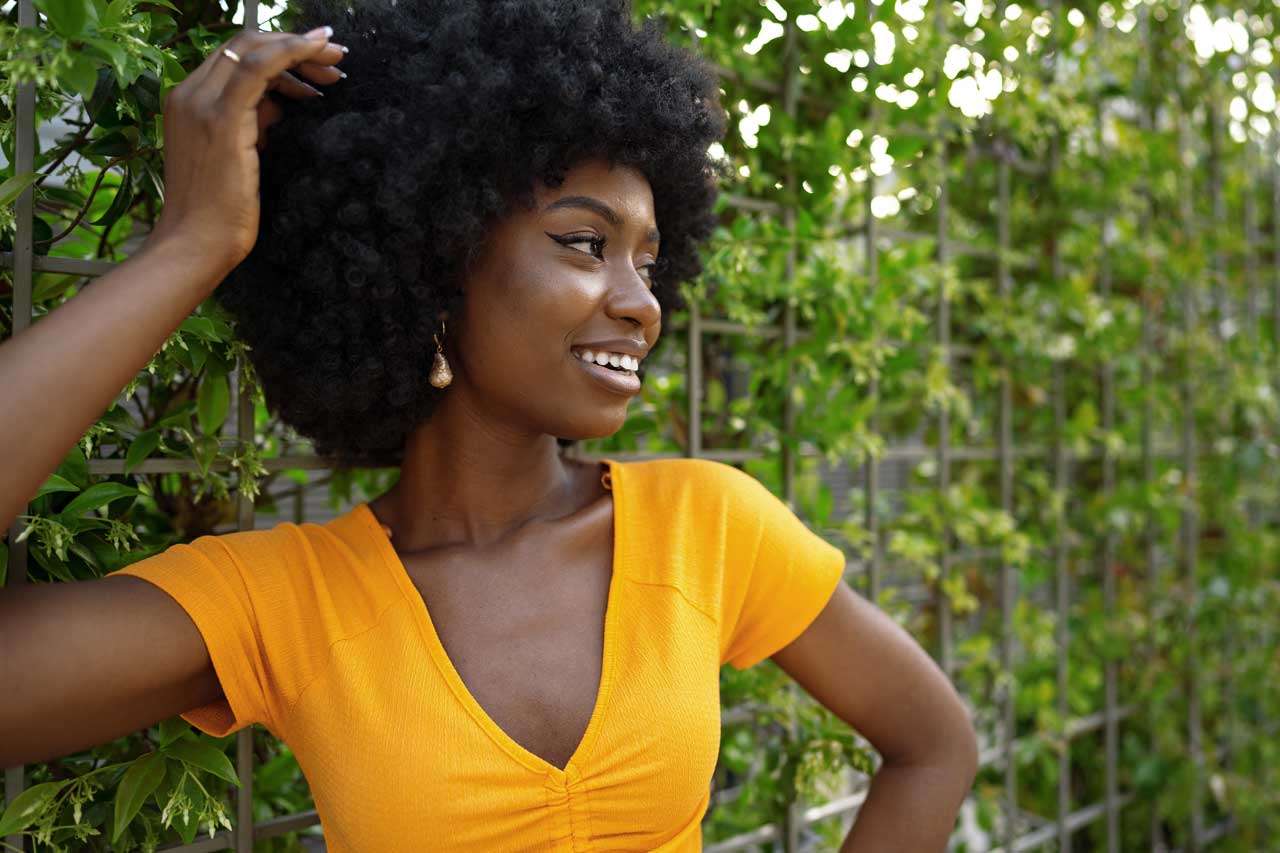 Smiling woman with curly hair outdoors