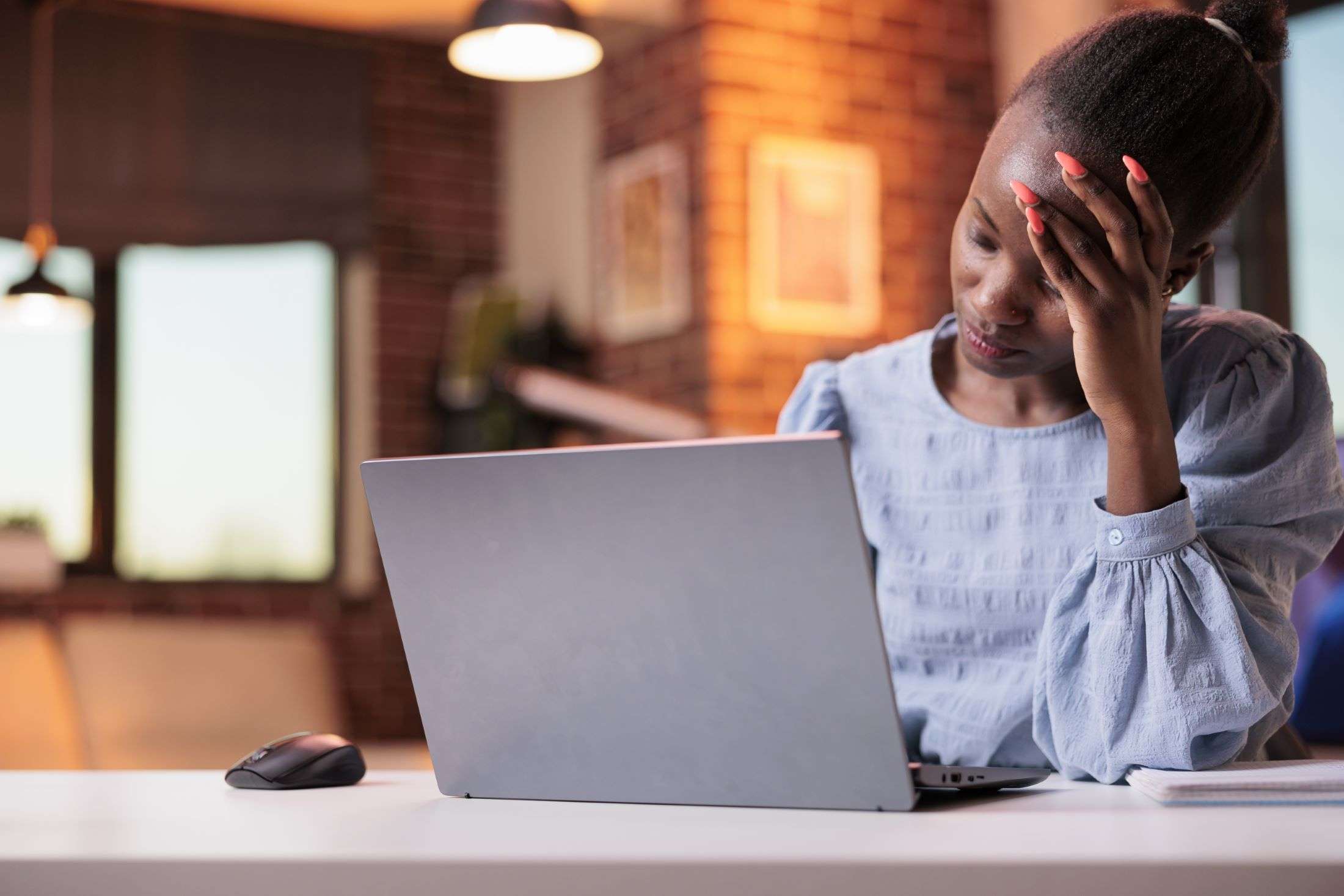 Woman stressed working on a laptop.